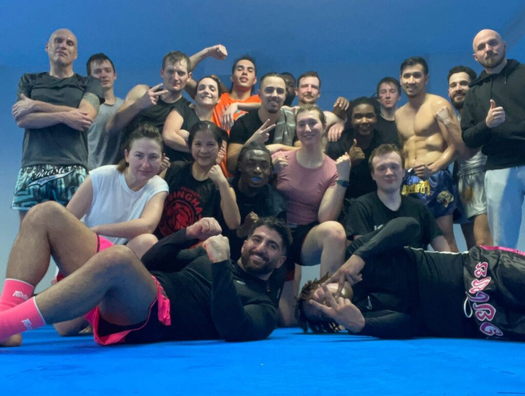 Unser Team, eine Gruppe von lachenden und glücklichen Muay Thai Kämpfern in Düsseldorf, die Gemeinschaft und Teamgeist zeigen